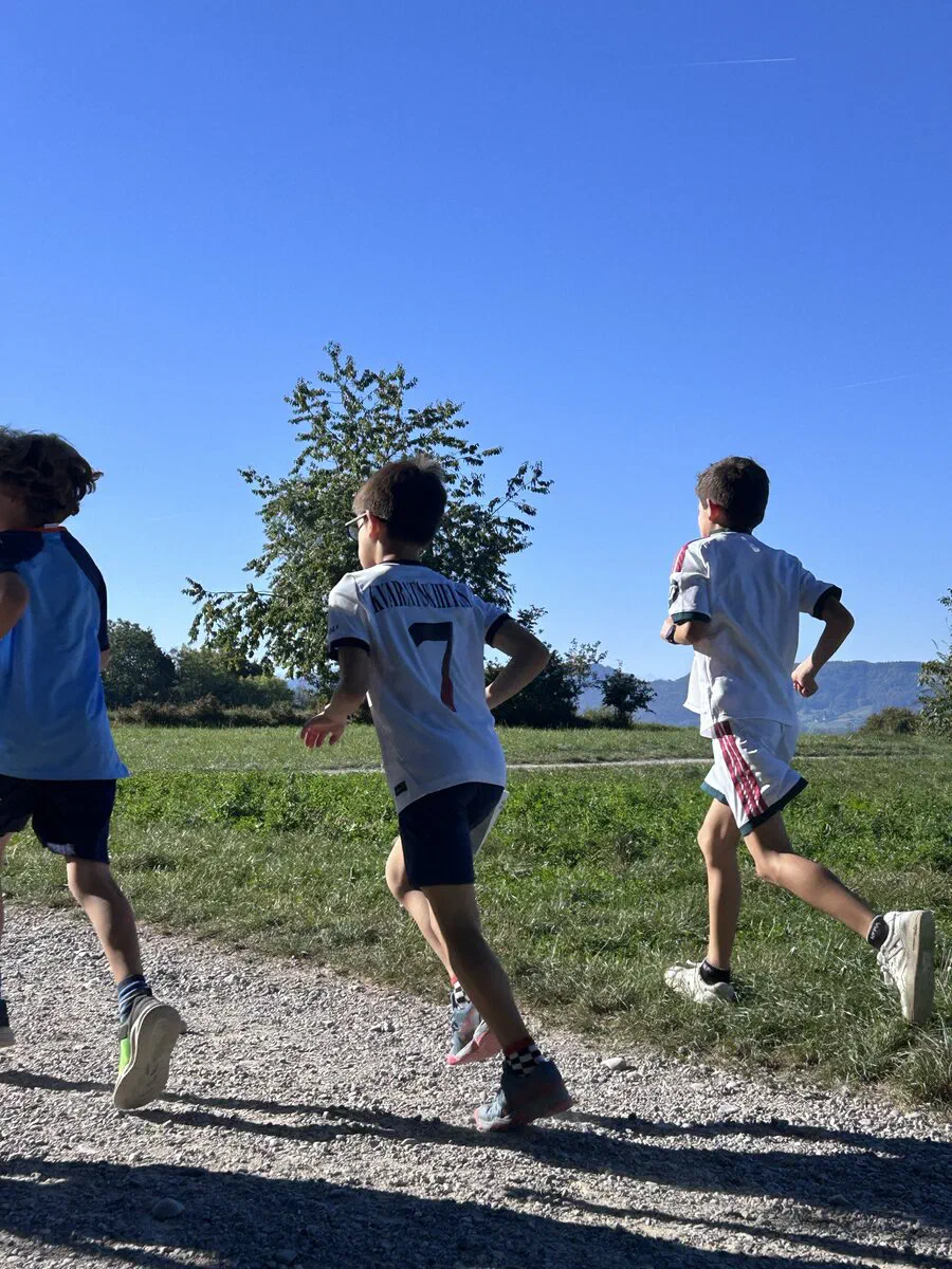 Kinder laufen bei blauem Himmel auf der Strecke